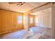 Living room with yellow paneled walls and damaged hardwood floors; needs renovations at 1520 S Michigan Ave, Clearwater, FL 33756