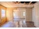 Empty living room with damaged flooring, yellow walls, and an opening to another room in the background at 1520 S Michigan Ave, Clearwater, FL 33756