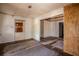 Spacious living room with hardwood floors, multiple doorways, paneled wall, closet and damaged ceiling at 1520 S Michigan Ave, Clearwater, FL 33756