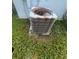 Close-up of the home's AC unit surrounded by grass at 1521 Atami Ct, Wesley Chapel, FL 33544