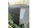 Exterior view of a gray air conditioner unit surrounded by some greenery at 1521 Atami Ct, Wesley Chapel, FL 33544