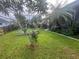 Spacious backyard with mature landscaping, a vegetable garden, and a covered patio, ideal for outdoor living at 1521 Atami Ct, Wesley Chapel, FL 33544