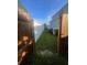 View of the backyard and the side of the house through an open gate at 1521 Atami Ct, Wesley Chapel, FL 33544