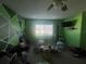 A green-painted bedroom featuring a window with blinds and a ceiling fan at 1521 Atami Ct, Wesley Chapel, FL 33544