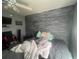 Bedroom featuring a large bed, ceiling fan, unique custom-painted wall and television at 1521 Atami Ct, Wesley Chapel, FL 33544