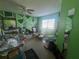 Bedroom featuring green geometric patterns painted on the wall, ceiling fan, and window at 1521 Atami Ct, Wesley Chapel, FL 33544