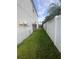 Narrow grassy area between the house and a white fence, offering privacy and space at 1521 Atami Ct, Wesley Chapel, FL 33544