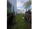 View through a wooden gate, showing the side yard and an outbuilding at 1521 Atami Ct, Wesley Chapel, FL 33544