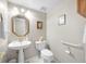 Neat half-bathroom featuring pedestal sink, toilet, and decorative wall art at 15711 Springmoss Ln, Tampa, FL 33624