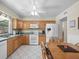 Traditional kitchen with wooden cabinets, tile floors, and modern appliances at 15711 Springmoss Ln, Tampa, FL 33624