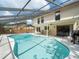 A private screened-in pool provides a refreshing escape, with space for entertaining on the patio at 15711 Springmoss Ln, Tampa, FL 33624