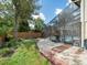 Outdoor pool area with brick pathway, rock landscaping, and screen enclosure for year-round enjoyment at 15711 Springmoss Ln, Tampa, FL 33624