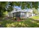Spacious backyard featuring lush greenery, a screened patio, and mature trees surrounding the property at 15722 Gardenside Ln, Tampa, FL 33624