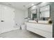 Well-lit bathroom featuring a double sink vanity with sleek fixtures, modern tile accents, and a toilet with storage at 15722 Gardenside Ln, Tampa, FL 33624
