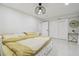 Bright bedroom with white floors, closet, and a bed with a yellow comforter at 15722 Gardenside Ln, Tampa, FL 33624