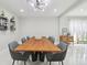 Elegant dining room featuring a stylish light fixture, sleek tile floors, and large table perfect for entertaining guests at 15722 Gardenside Ln, Tampa, FL 33624