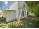 Exterior shot showing the side of the house, including a well-maintained lawn and mature trees in the landscape at 15722 Gardenside Ln, Tampa, FL 33624