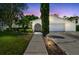 Exterior view of a home at dusk, featuring landscaped front yard and an arched entrance with subtle outdoor lighting at 15722 Gardenside Ln, Tampa, FL 33624