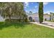 Well-maintained home with a green lawn, mature landscaping, and a unique arched entryway, creating curb appeal at 15722 Gardenside Ln, Tampa, FL 33624