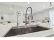 Modern kitchen island with bar stool seating, and stainless steel sink at 15722 Gardenside Ln, Tampa, FL 33624