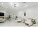 Spacious, bright living room with white ceramic flooring, modern lighting, and access to the backyard through french doors at 15722 Gardenside Ln, Tampa, FL 33624