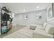 Bright living room featuring a sectional sofa, shelving, and natural light from windows at 15722 Gardenside Ln, Tampa, FL 33624