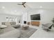 Open living room with high ceiling, fireplace, white ceramic floors and french doors leading to the backyard at 15722 Gardenside Ln, Tampa, FL 33624