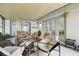 Enclosed sunroom featuring comfortable seating, lighting, and outdoor views at 15722 Gardenside Ln, Tampa, FL 33624