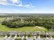 An aerial view displays a row of charming homes and lush green spaces under a partly cloudy sky in a serene community at 1827 Trillium Blvd, Brooksville, FL 34604
