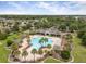 Aerial view of the large community pool with lounge chairs and shaded seating areas surrounded by lush landscaping at 1827 Trillium Blvd, Brooksville, FL 34604