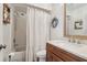 Cozy bathroom with wood vanity, quartz countertop, framed mirror, and shower/tub combination at 1830 Cypress Trace Dr, Safety Harbor, FL 34695