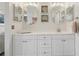 Bathroom features a white vanity, framed mirrors, updated lighting, and modern finishes at 1830 Cypress Trace Dr, Safety Harbor, FL 34695