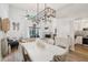 Open-concept dining area with elegant chandelier, flowing into living space and kitchen with fireplace at 1830 Cypress Trace Dr, Safety Harbor, FL 34695