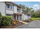 Two-story home with neutral paint, landscaping, and a private walkway leading to the entrance at 1830 Cypress Trace Dr, Safety Harbor, FL 34695