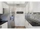Stylish kitchen boasts stainless steel refrigerator, mosaic backsplash, granite counters, and ample cabinet space at 1830 Cypress Trace Dr, Safety Harbor, FL 34695