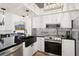 Modern kitchen features stainless steel appliances, black countertops, mosaic tile backsplash, and updated cabinetry at 1830 Cypress Trace Dr, Safety Harbor, FL 34695