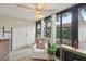 Bright sunroom with large windows, white chair, ceiling fan, and peaceful views of the outdoors at 1830 Cypress Trace Dr, Safety Harbor, FL 34695