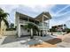 Rear exterior view of the home showing a large covered deck overlooking the beautiful backyard at 19111 Whispering Pines Dr, Indian Shores, FL 33785