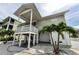 Side view of a charming raised stilt home with stairs leading up to the covered porch at 19111 Whispering Pines Dr, Indian Shores, FL 33785