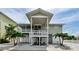 Bright beach home featuring a covered porch, ground-floor entrances, and easy beach access at 19111 Whispering Pines Dr, Indian Shores, FL 33785