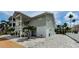 Exterior view of a home with a large driveway area and access to multiple garages at 19111 Whispering Pines Dr, Indian Shores, FL 33785