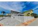 Exterior of a two-story home with a paved driveway and white fencing for privacy at 19111 Whispering Pines Dr, Indian Shores, FL 33785