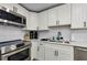 This kitchen offers white cabinets, stainless steel appliances, and subway tile backsplash at 19111 Whispering Pines Dr, Indian Shores, FL 33785