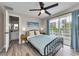 A serene bedroom featuring wood floors, balcony access, and an en-suite bathroom at 19111 Whispering Pines Dr, Indian Shores, FL 33785