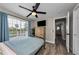 The bedroom with wood floors, a chest of drawers and a balcony offers natural light at 19111 Whispering Pines Dr, Indian Shores, FL 33785