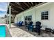 Covered outdoor patio area displaying various seating options and paver flooring at 19111 Whispering Pines Dr, Indian Shores, FL 33785