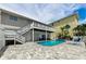 Backyard pool and spa area with lounge chairs, outdoor dining, and second story deck at 19111 Whispering Pines Dr, Indian Shores, FL 33785