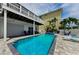 Backyard pool featuring a spa, lounge seating, grill, and tropical landscaping at 19111 Whispering Pines Dr, Indian Shores, FL 33785
