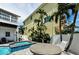 Inviting pool area with lush tropical landscaping, barbecue grill, and outdoor dining at 19111 Whispering Pines Dr, Indian Shores, FL 33785