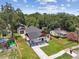 Aerial view of a completely fenced in yard with a charming home, a detached garage, and landscaping at 1914 E Chelsea St, Tampa, FL 33610